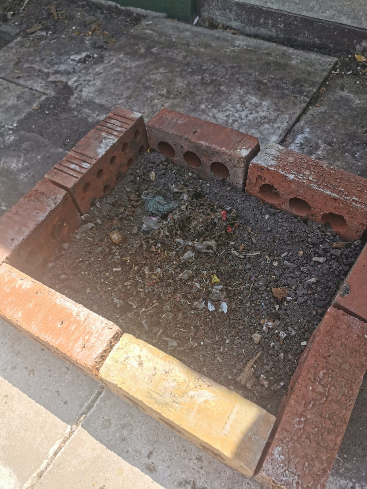 A brick-edged roof area full of nesting debris