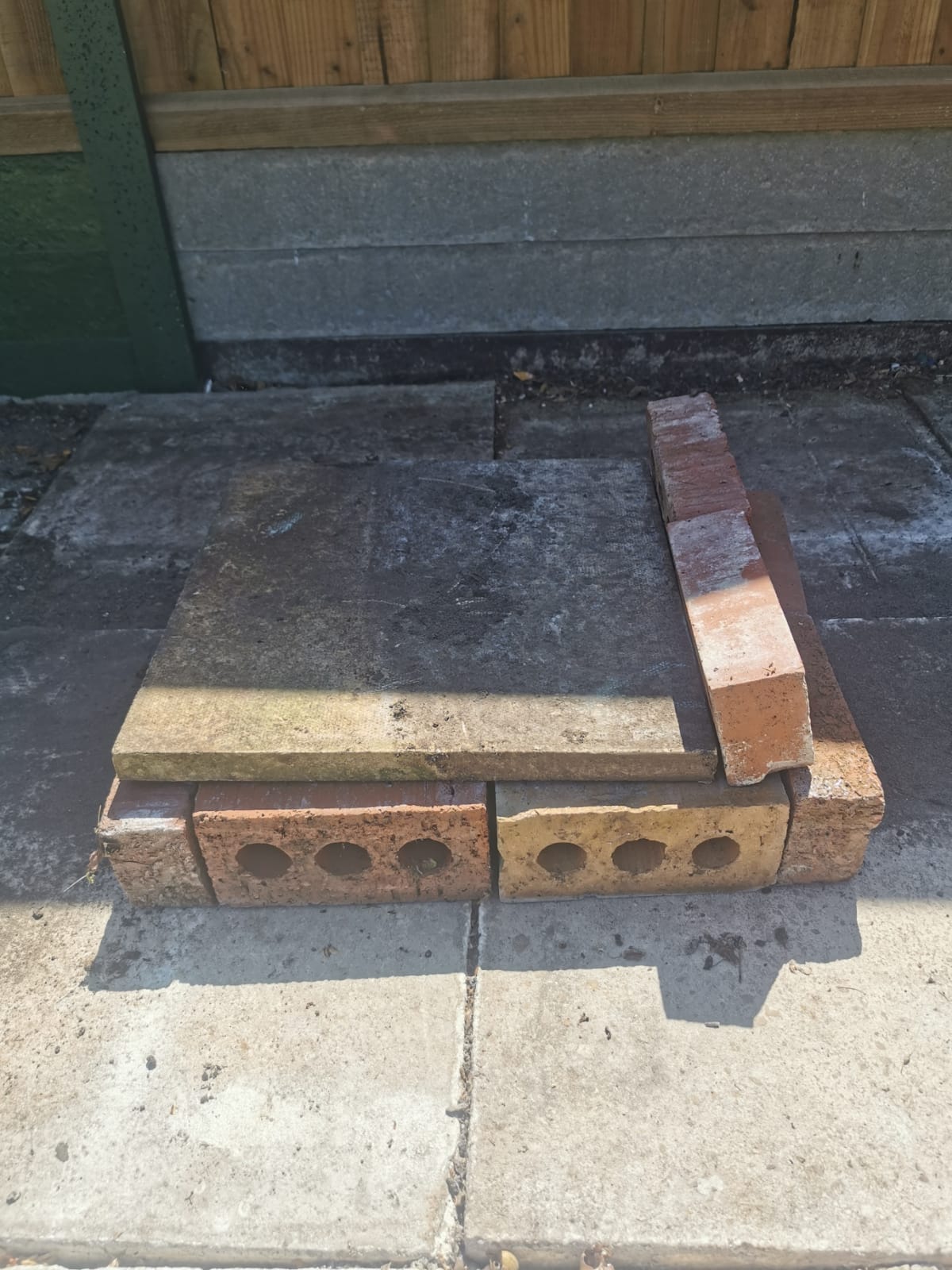 The roof area cleared, with a paving slab and bricks stacked